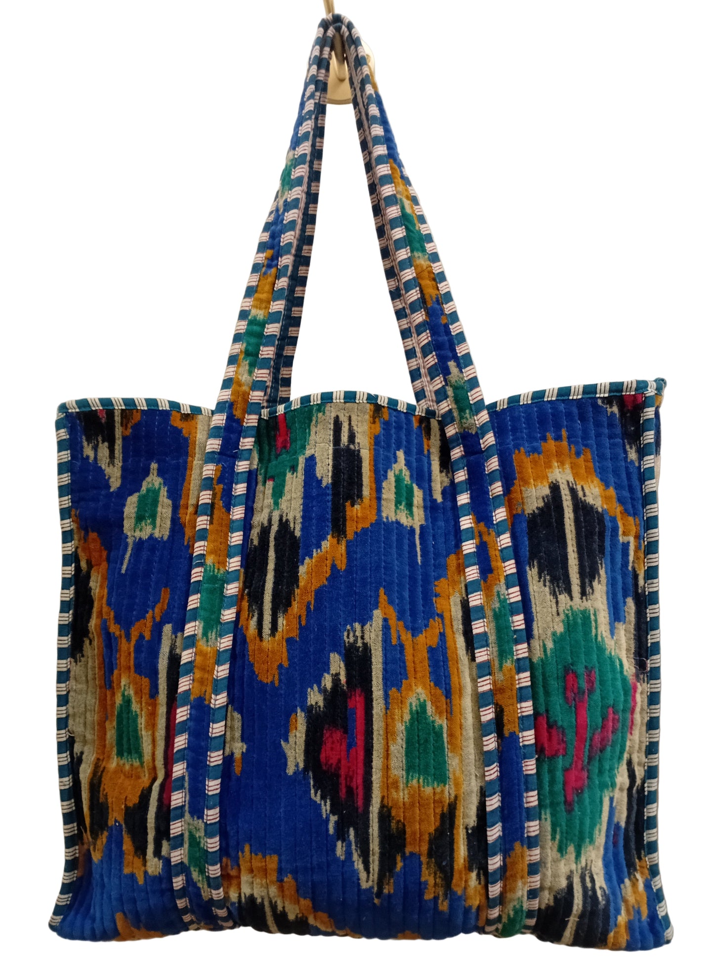 Colorful woven bag with geometric pattern on a blue background