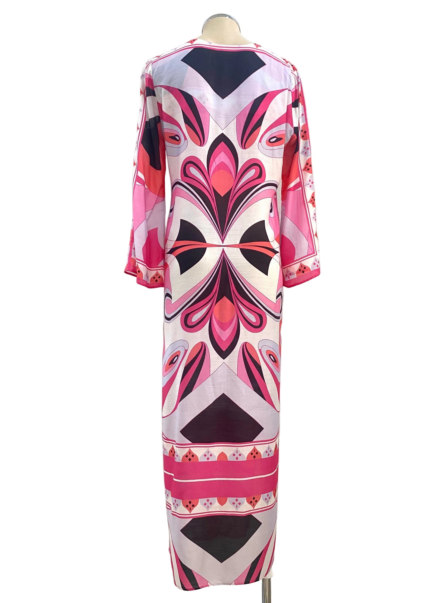 Colorful patterned dress on a mannequin against a white wall