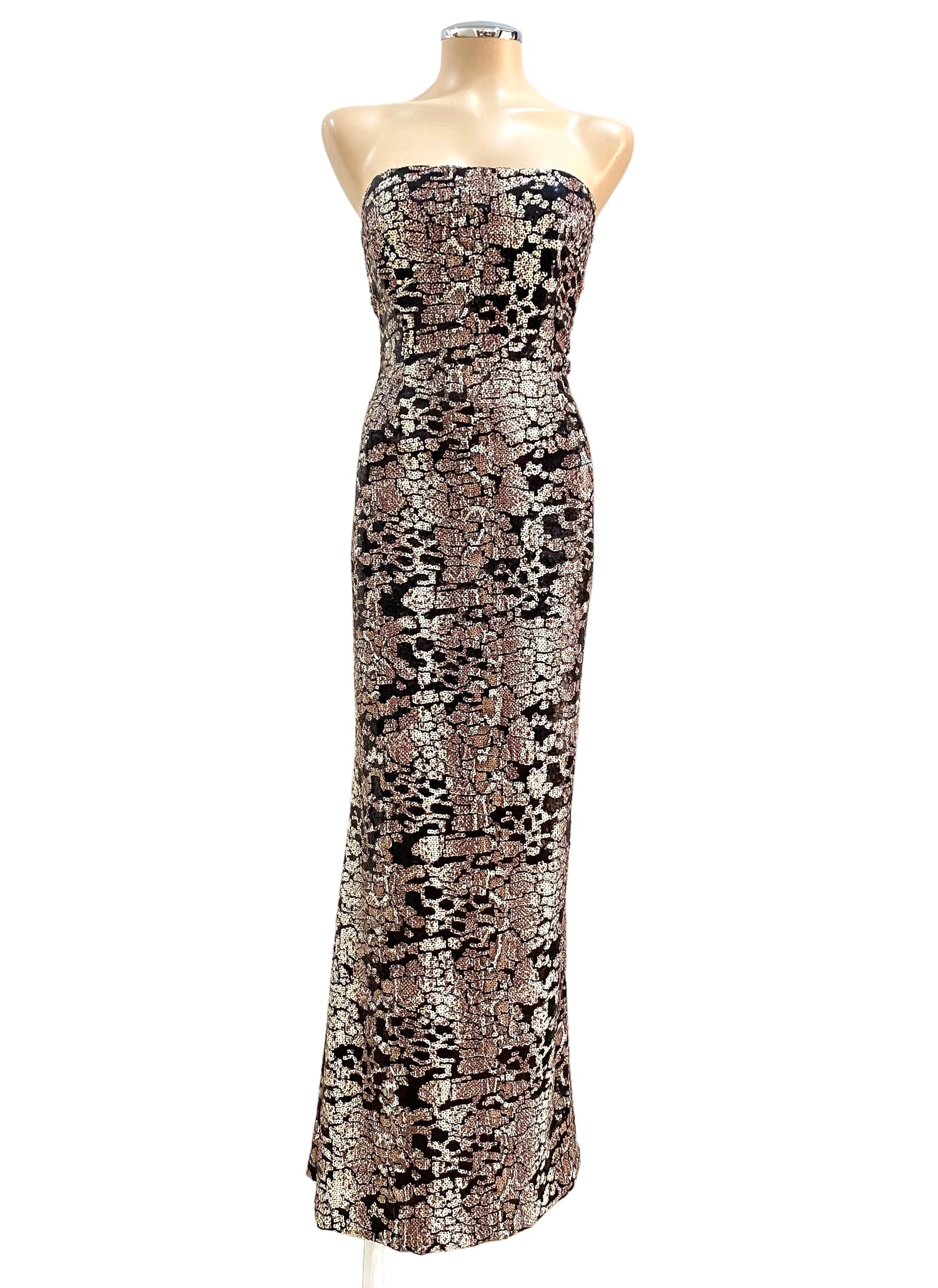 Patterned strapless dress on a mannequin against a white wall.