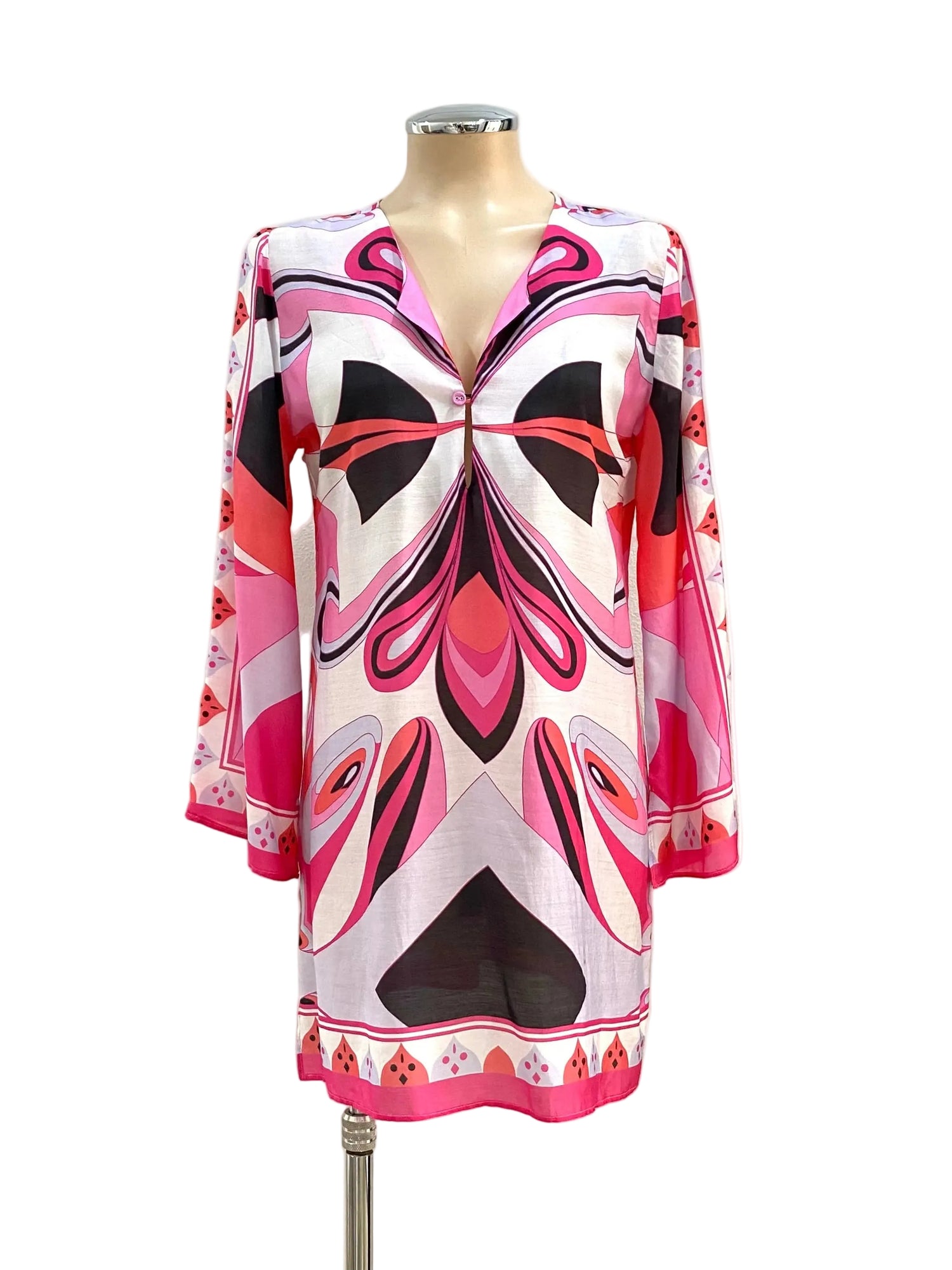 Colorful dress on a mannequin against a white wall.