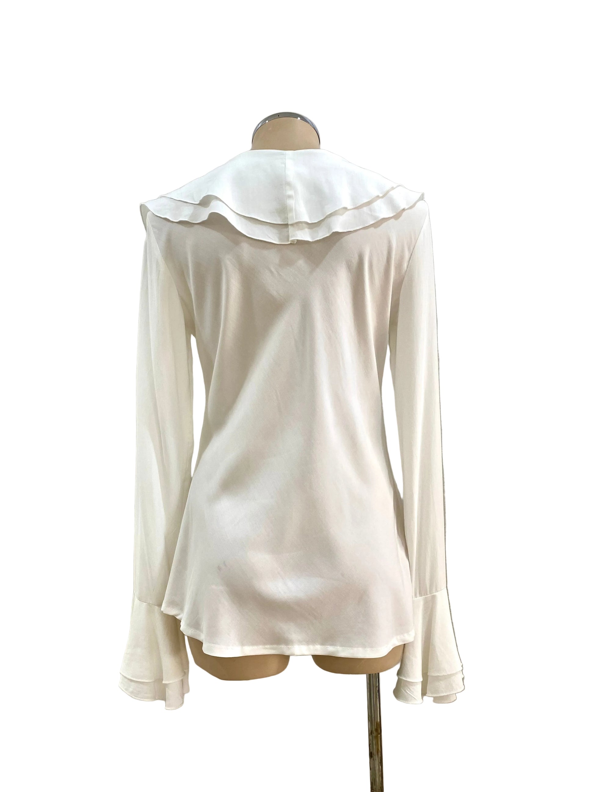 White ruffled blouse on a mannequin against a white wall