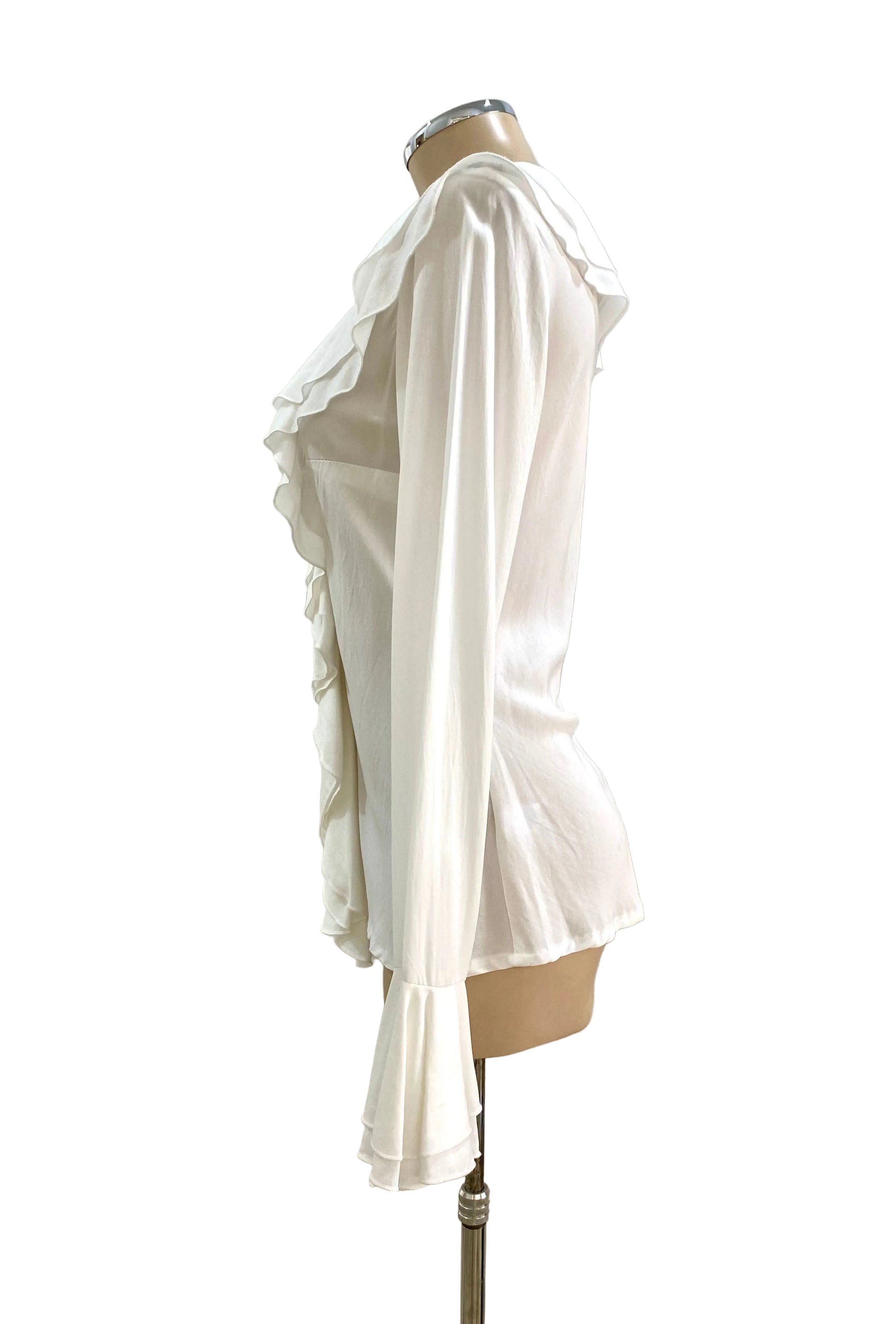White ruffled blouse on a mannequin against a white wall