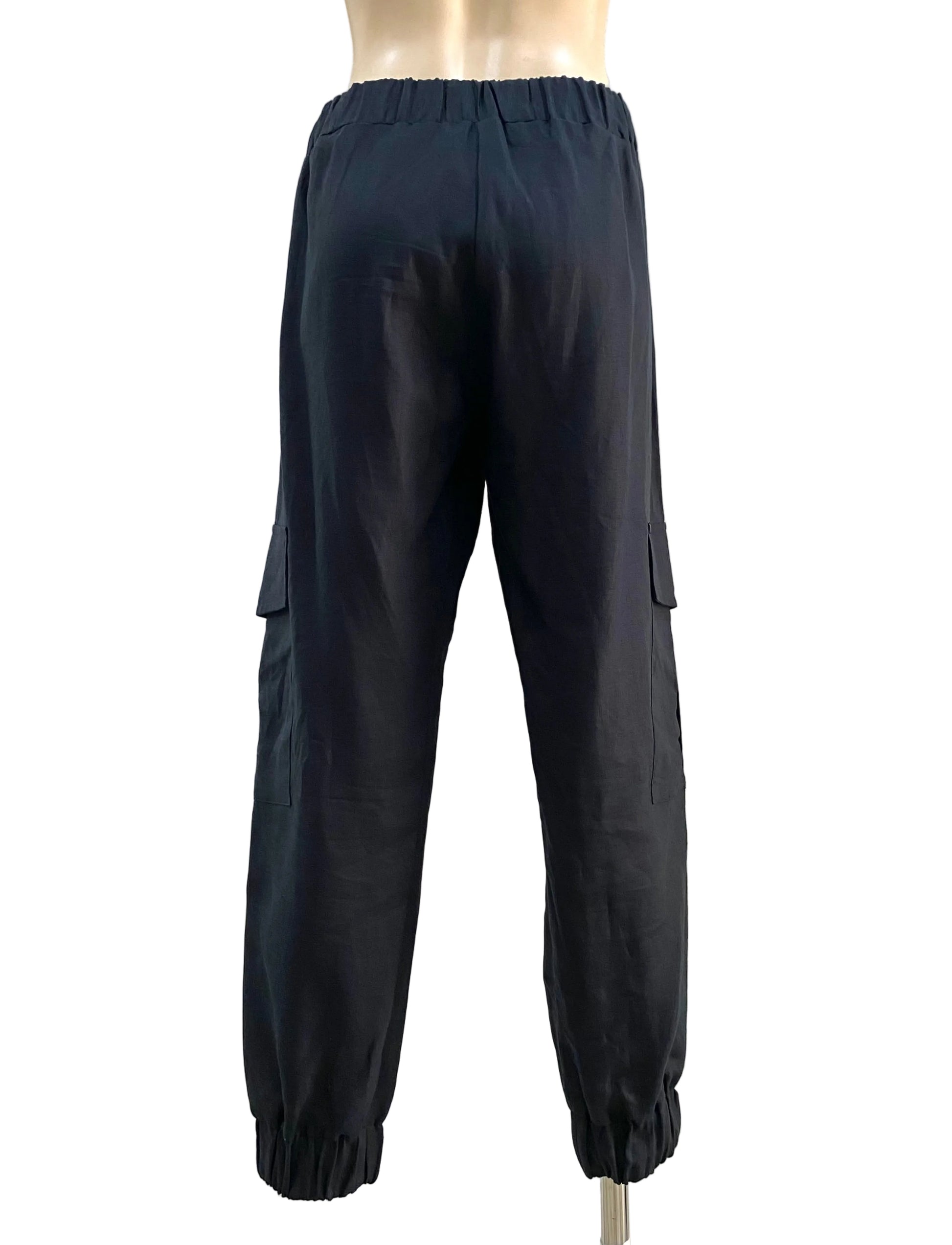 Black cargo pants on a mannequin against a white wall