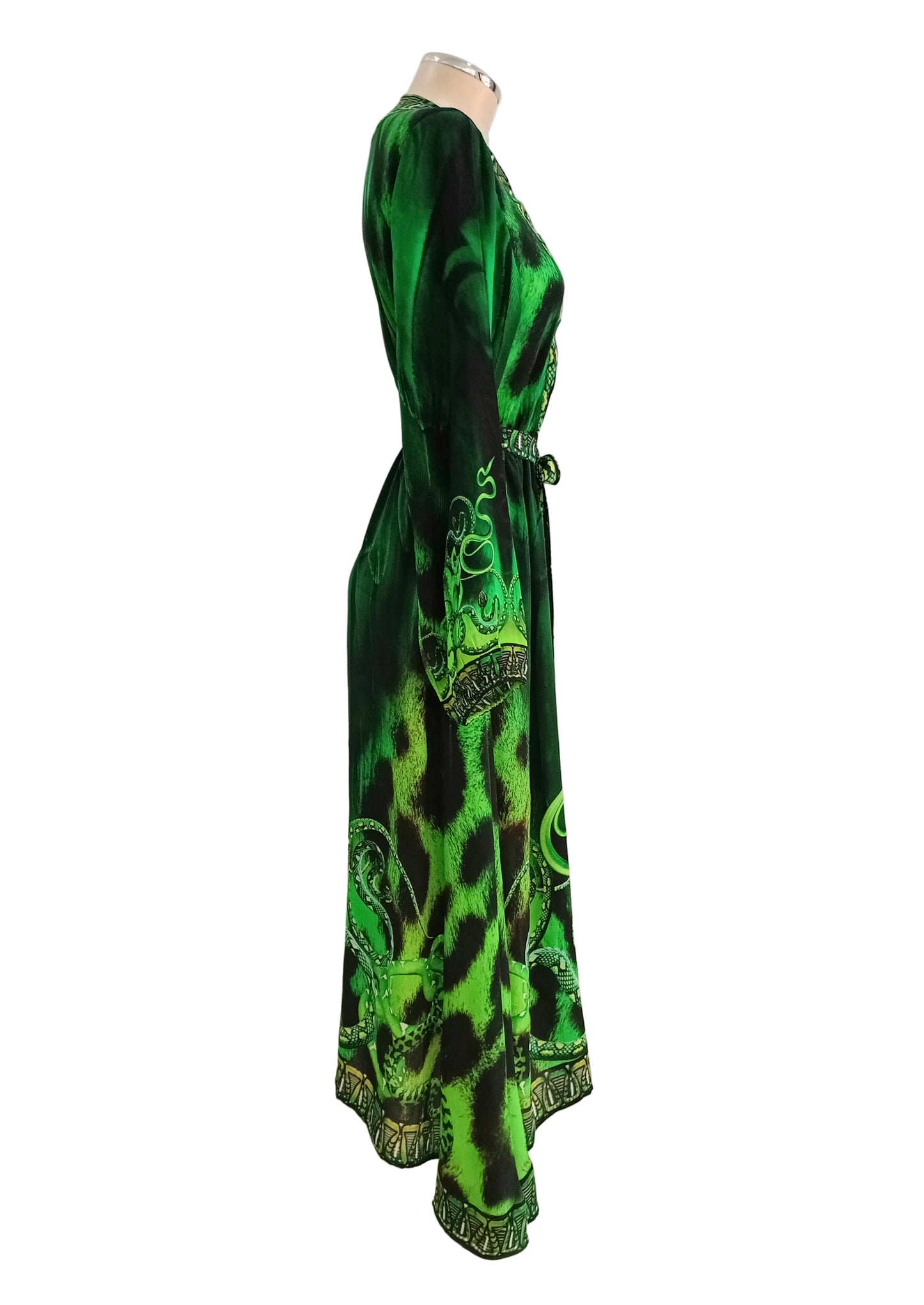Medusa Green and black patterned wrap dress against a white wall.