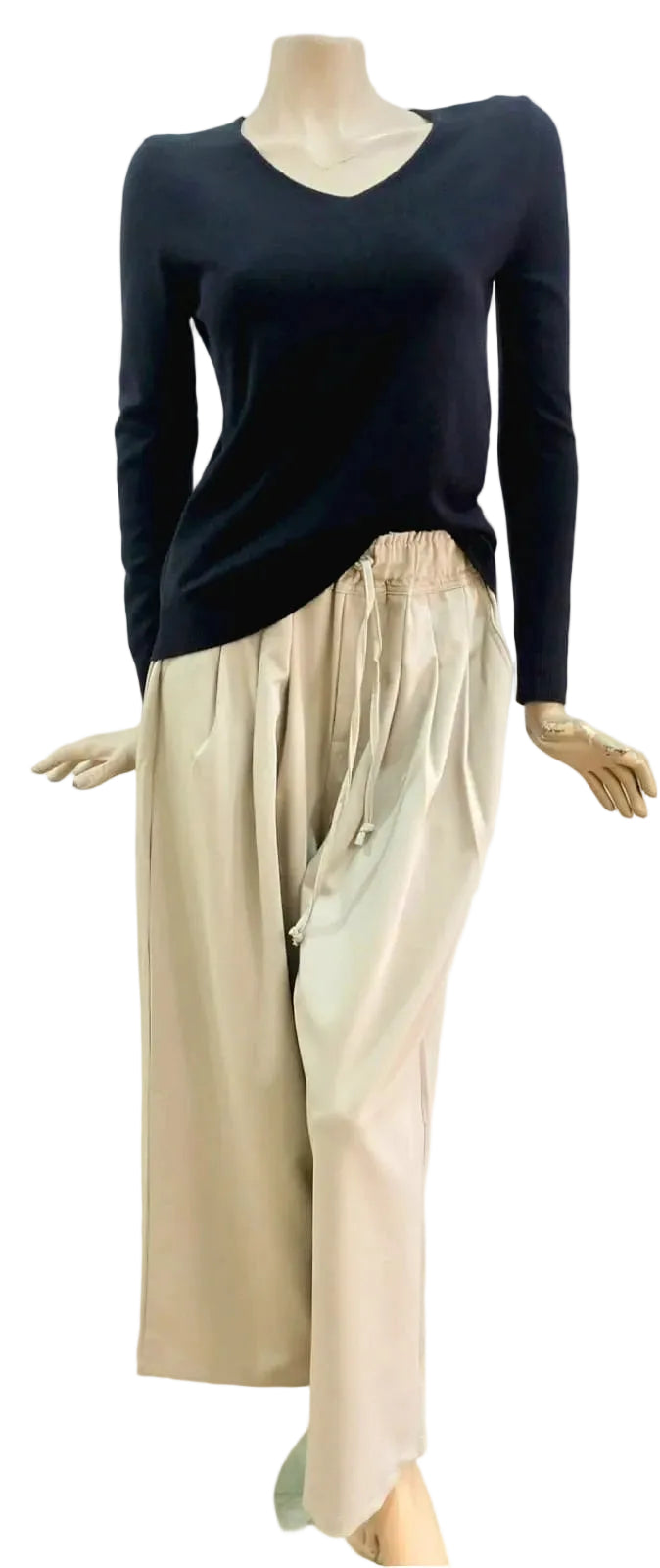 Stone wide-leg  pants with pleated detail against a white wall.