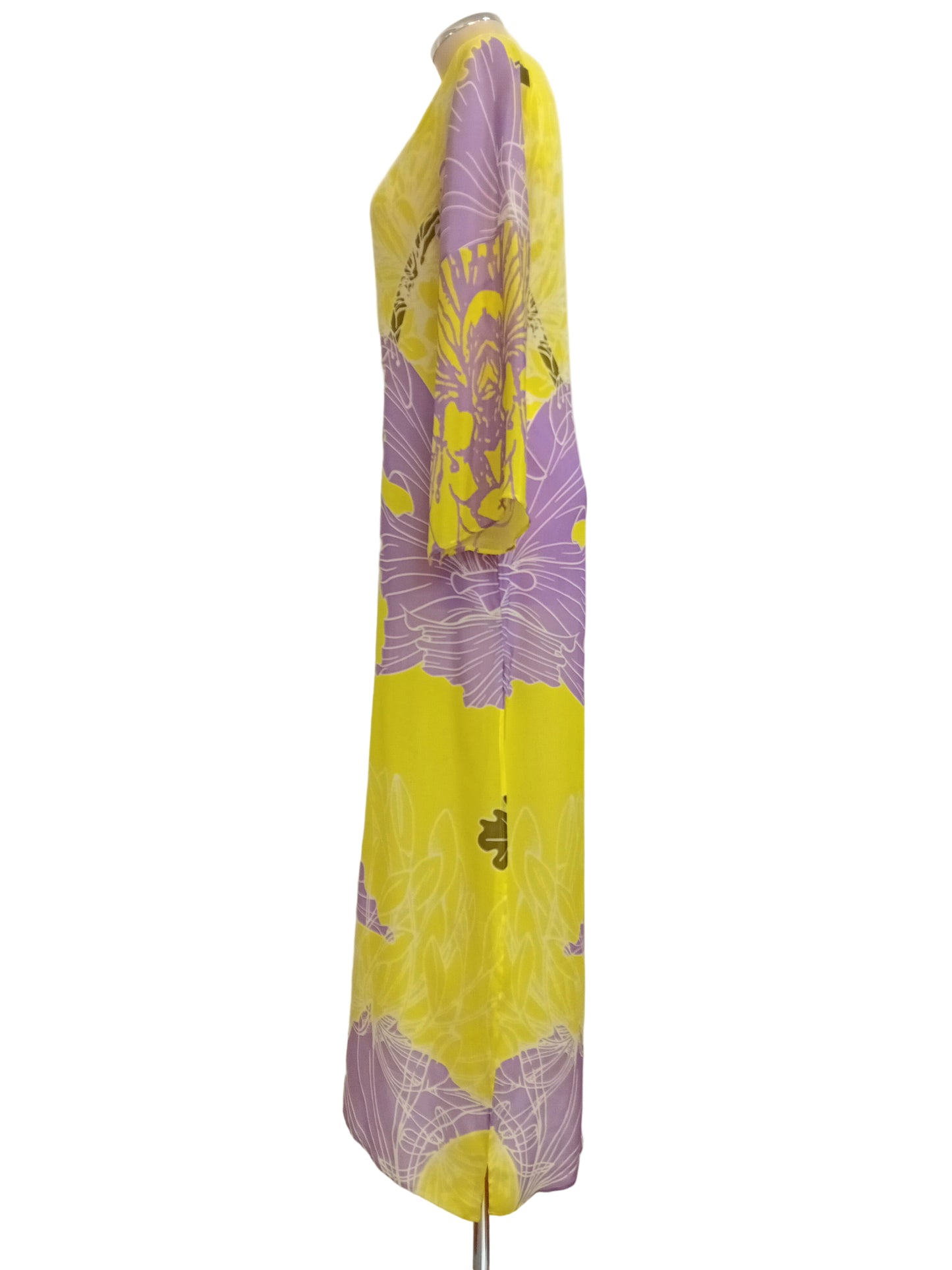 Tunic dress with yellow and purple floral print against a white wall