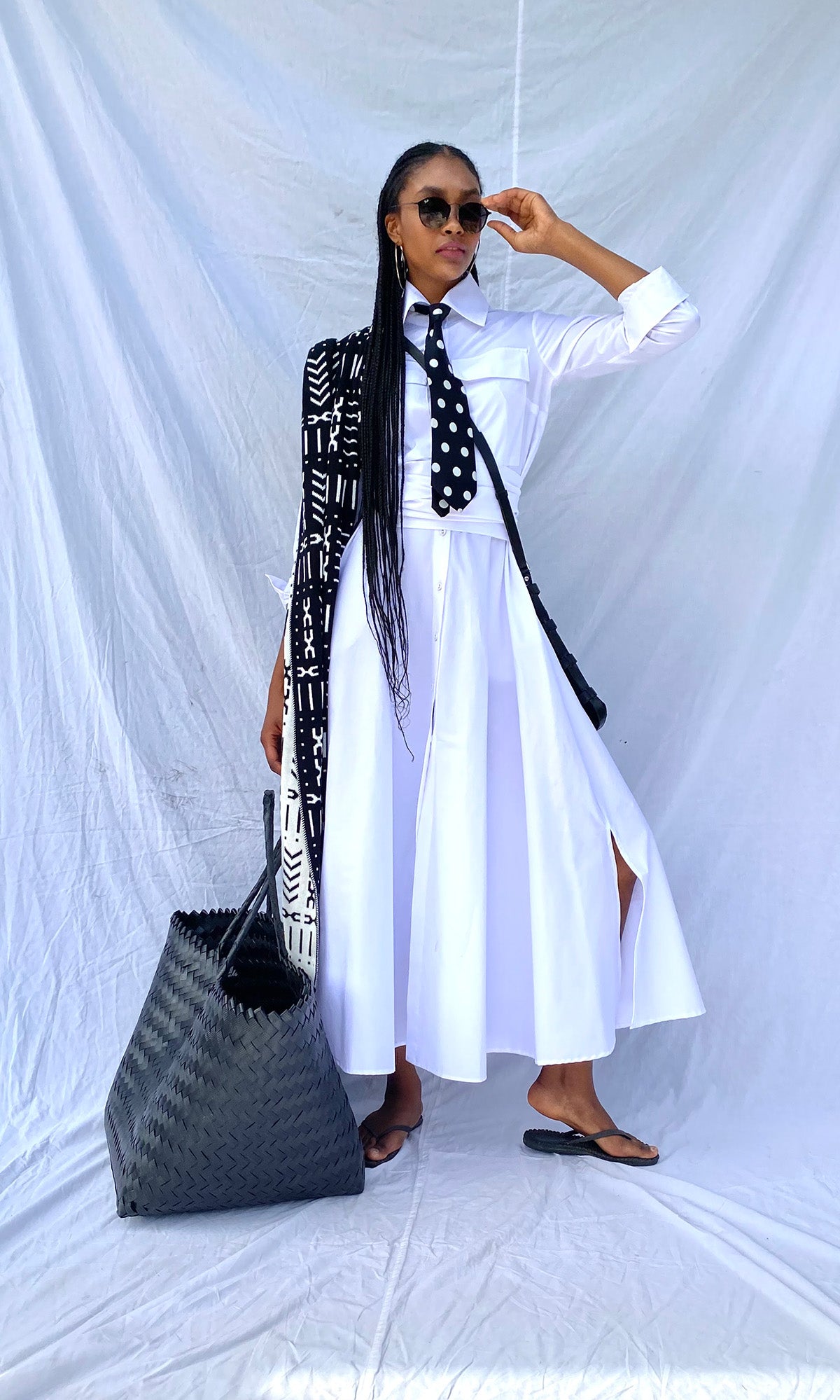 White shirtwaister dress on model with white fabric background and black accessories